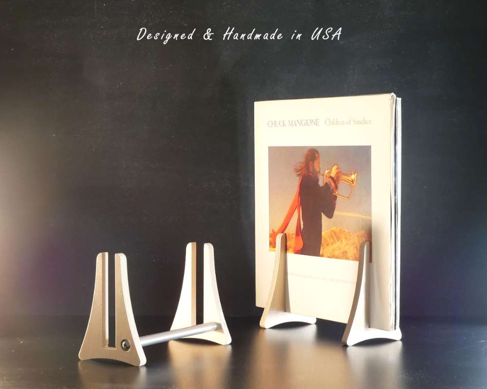 A wood stand holding five vinyl record albums in avertical position