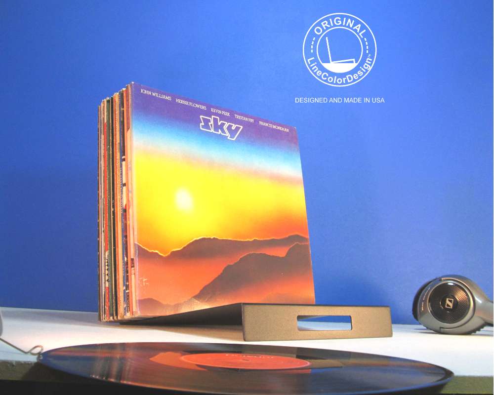 a leaning black metal stand holding vinyl records