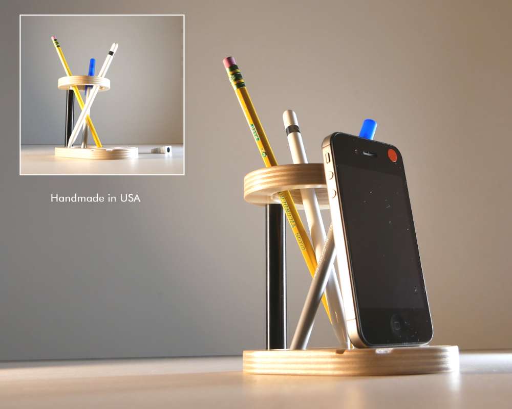 a circular pen holder with a cellphone leaning up against it
